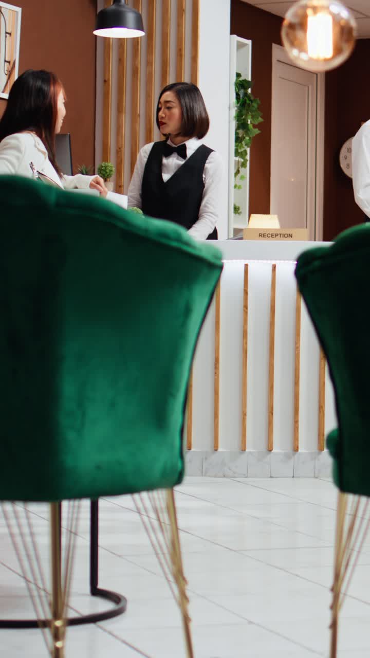 Video verticale: personale della reception che accoglie due ospiti in un resort a cinque stelle
