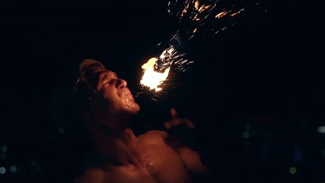 Young-blond-male-breathes-out-large-stream-of-fire-making-fireball-Slow-motion