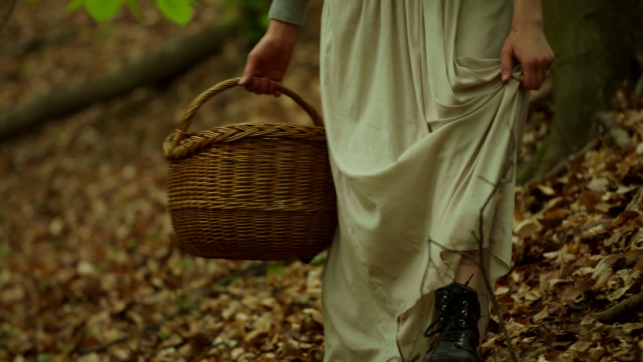 Donna che raccoglie nel bosco autunnale