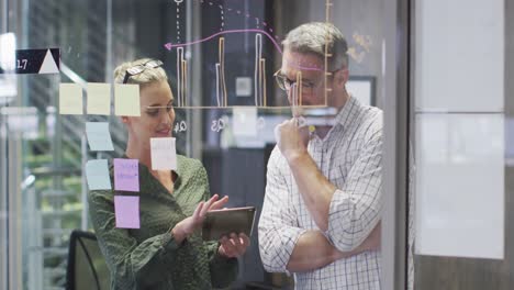 video of happy caucasian female and male designers brainstorming in office