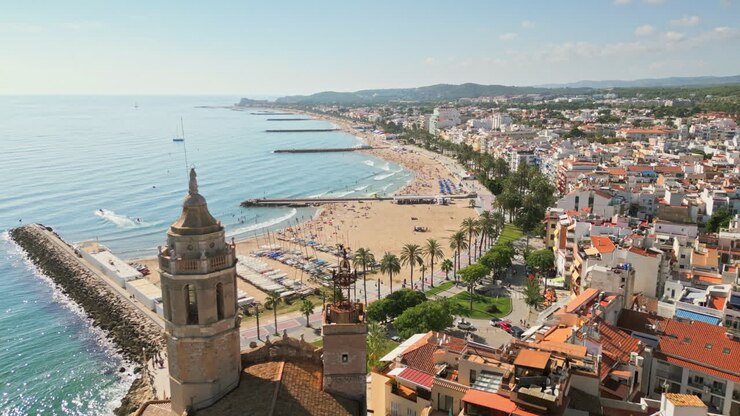 Drone captures aerial footage of an ancient church overseeing coastal town by sea on a sunny day