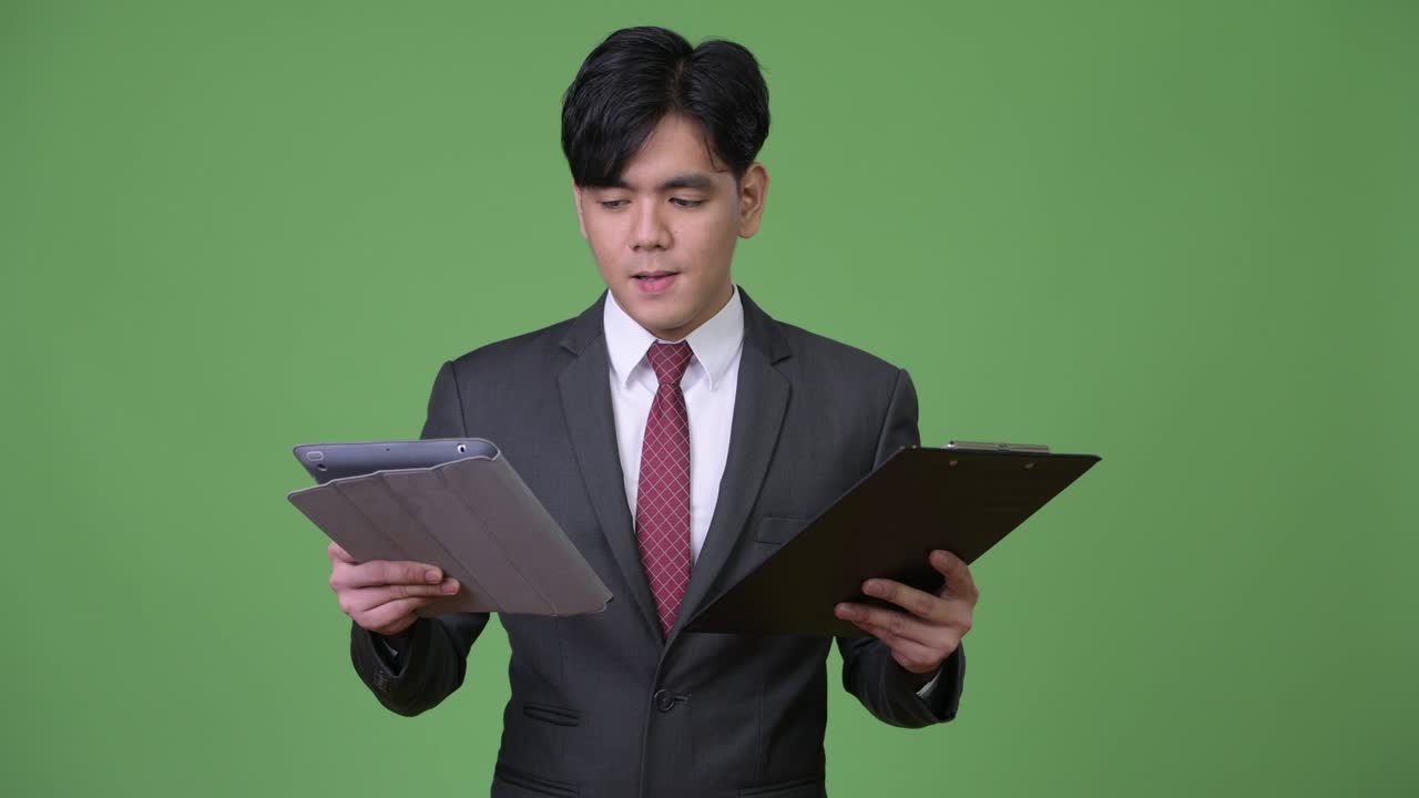 年轻帅气的亚洲商人使用平板电脑