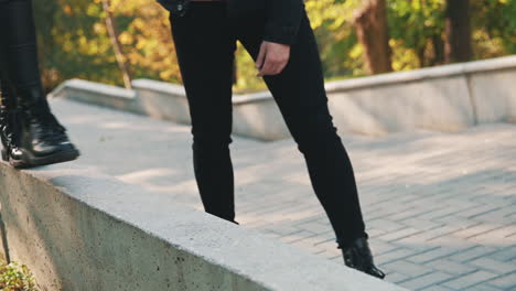 woman's boots walking on a curb with the help of her boyfriend