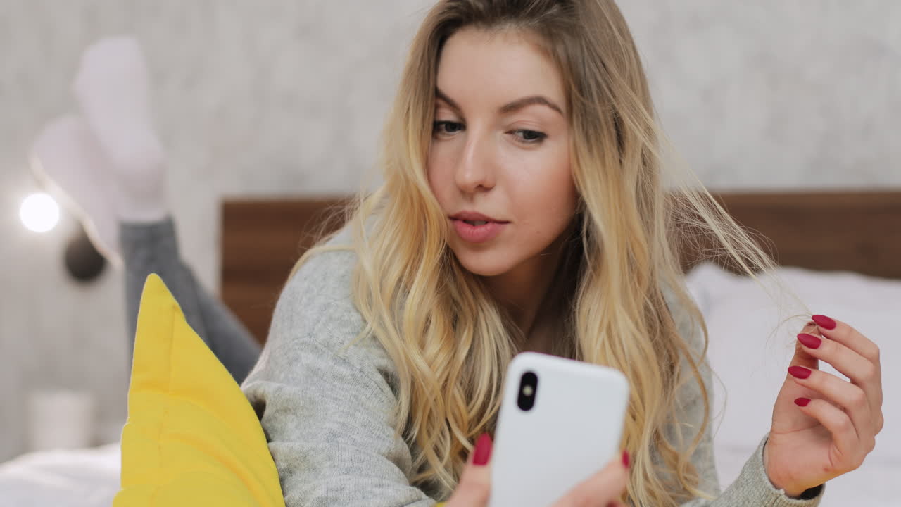 Woman taking a selfie on her bed