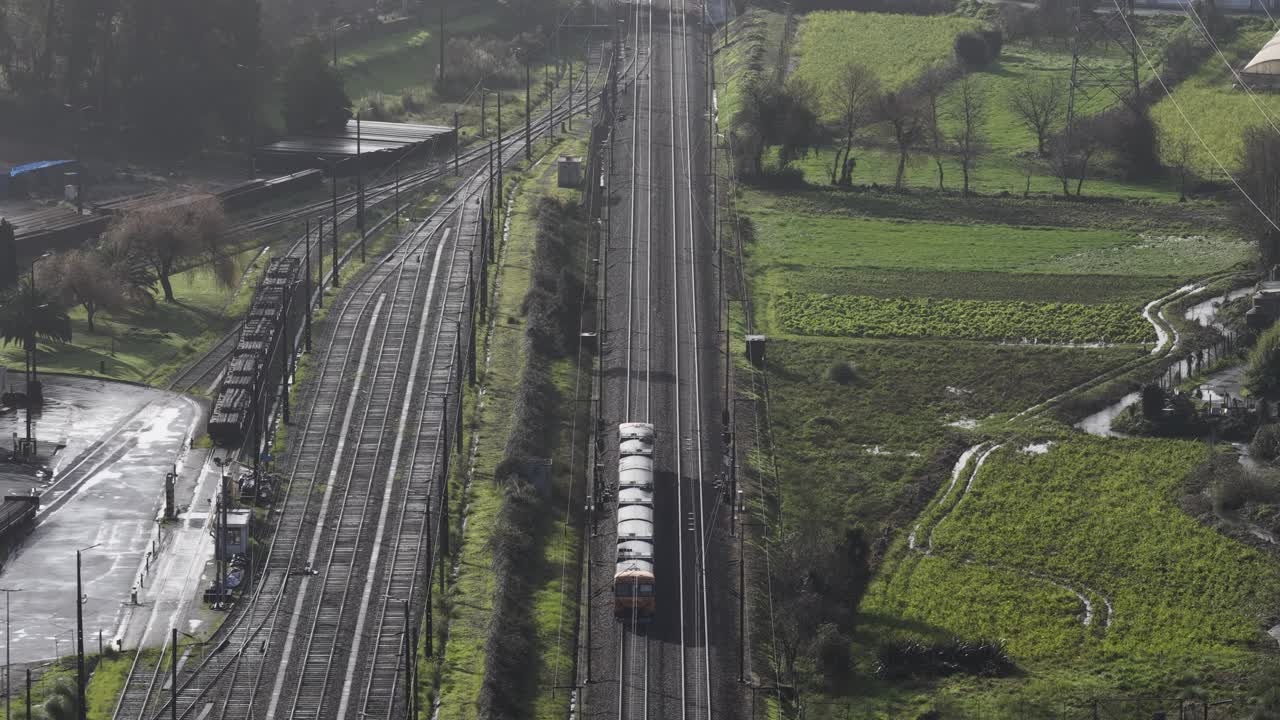 Zona industriale e treno che viaggia sui binari.