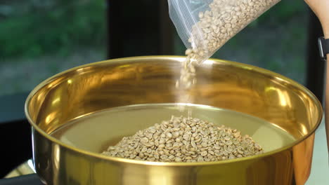 pouring raw coffee beans into a modern machine