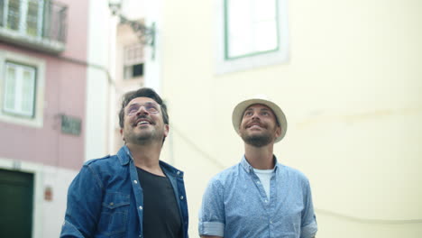 front view of excited gay couple looking the buildings in city