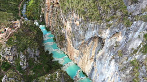 increíble drone aéreo disparado acercándose suavemente a un lago con agua turquesa llamado millpu ubicado en ayacucho en perú en una tarde calurosa