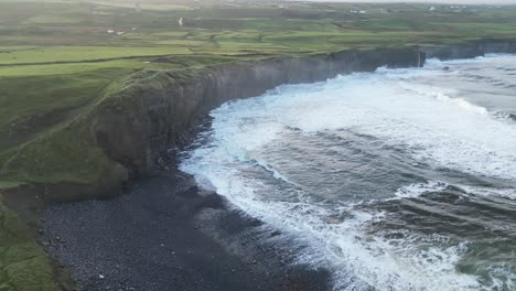 aerial establishing shot of sets of waves crashing on doolin beach