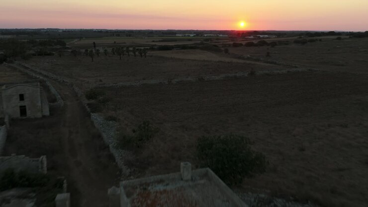 Le rovine di Masseria Cippano al tramonto, storica masseria fortificata, splendido paesaggio rurale in Puglia, Italia. Avvicinamento aereo, spazio per la copia