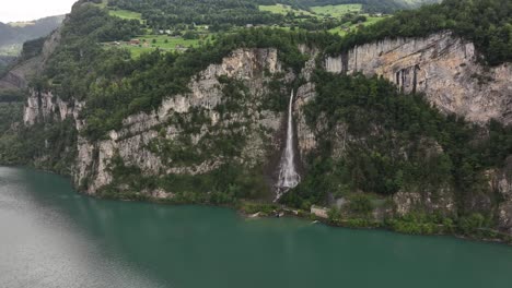 Drone view of Seerenbachfälle waterfall cascading down steep cliffs into Walensee, Switzerland