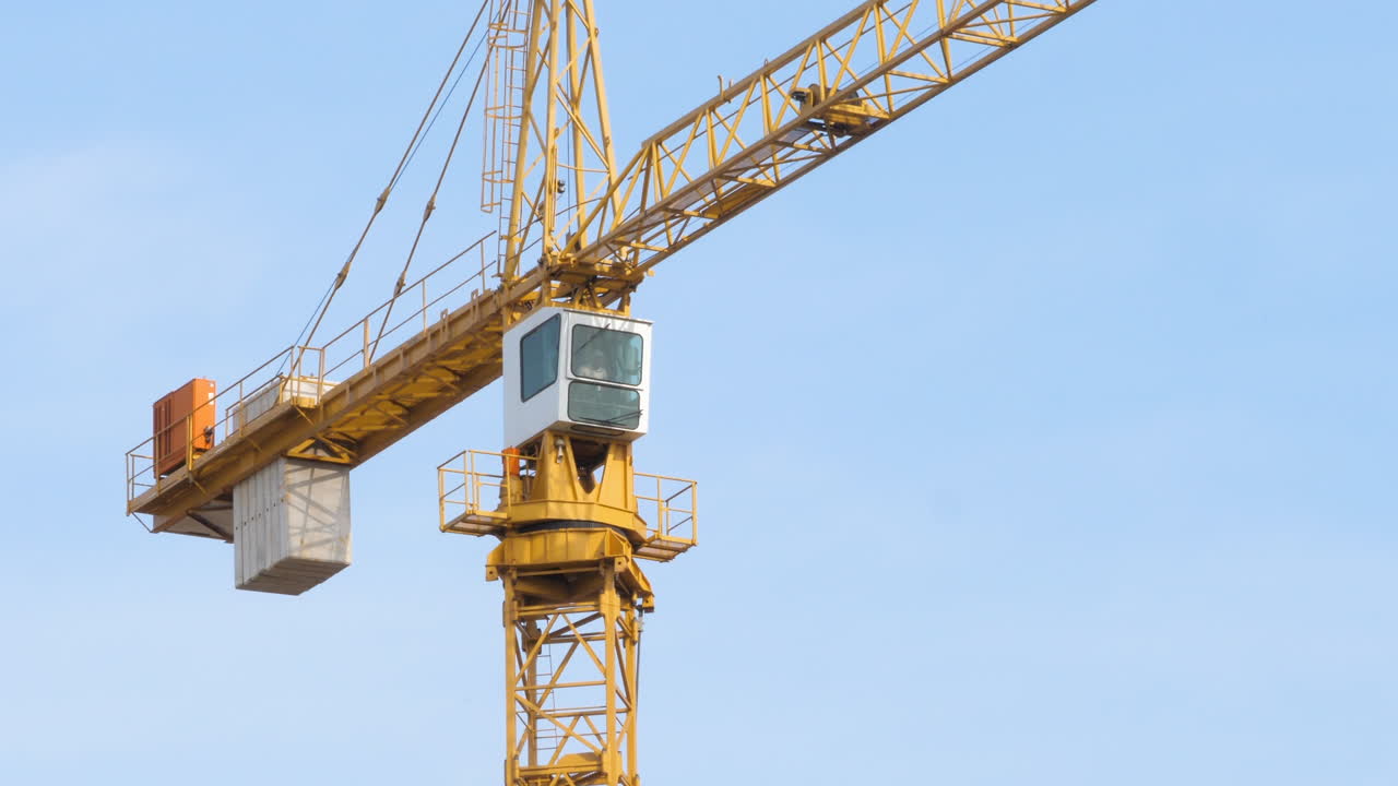 바람이 부는 날 작동 중인 건설 타워 크레인을 닫습니다