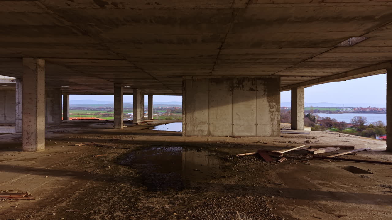 Una struttura abbandonata rivela la bellezza dimenticata del degrado urbano con vista su acque serene e paesaggi lontani al crepuscolo