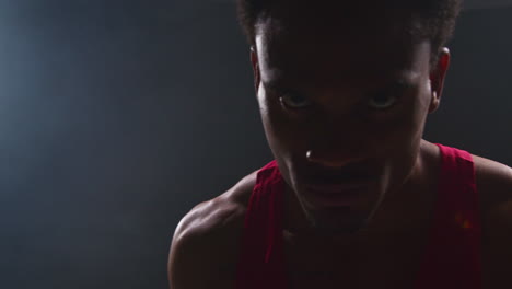 Close-Up-Portrait-Of-Boxer-Pointing-At-Camera-With-Boxing-Glove-In-Ring-Before-Start-Of-Boxing-Match