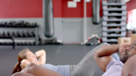 Fit-African-American-man-and-young-Caucasian-woman-exercising-at-the-gym