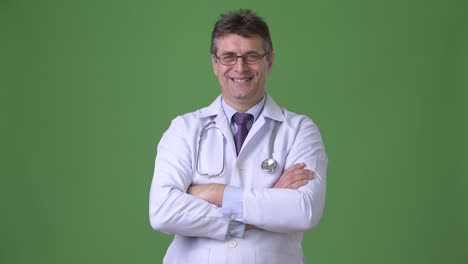 hombre maduro y guapo médico contra fondo verde