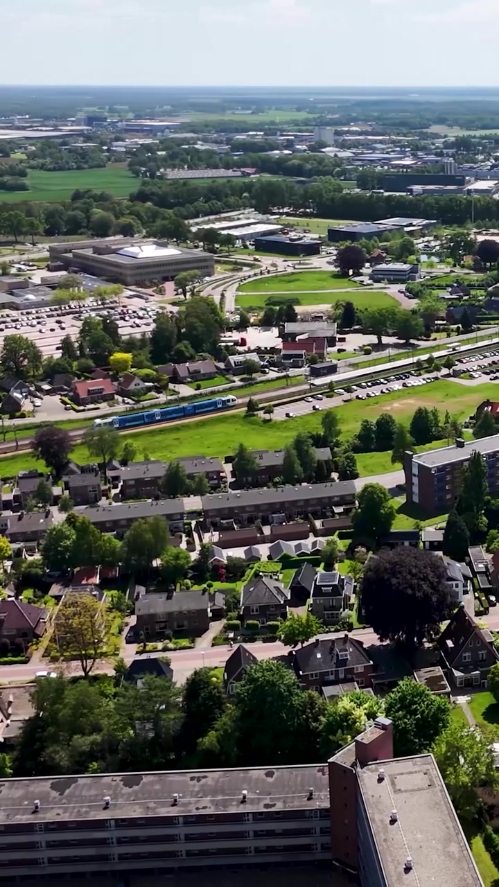 Vista aerea di una città suburbana con un treno in movimento