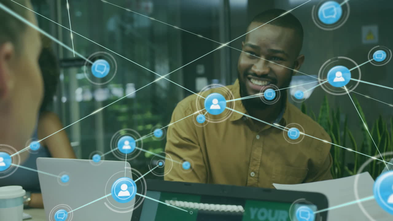 Animation of network of connections with icons over diverse colleagues using laptop in office