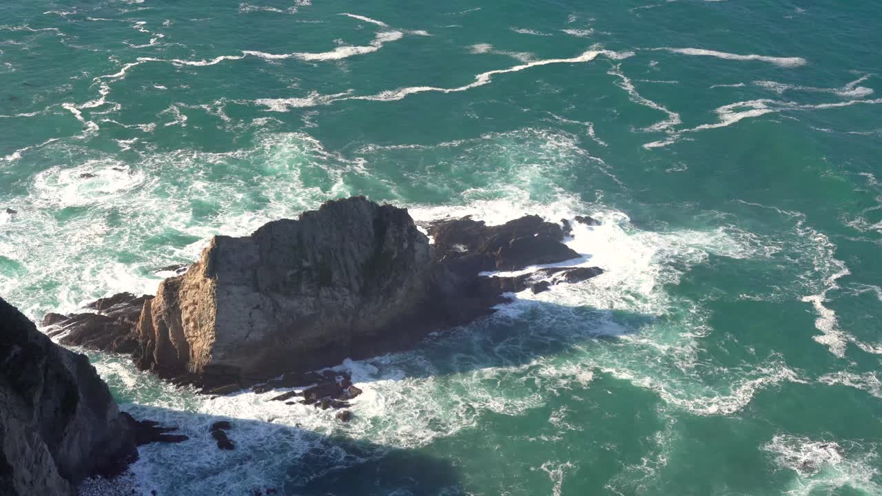 olas oceánicas rompiendo en afloramientos rocosos en big sur, california en verano