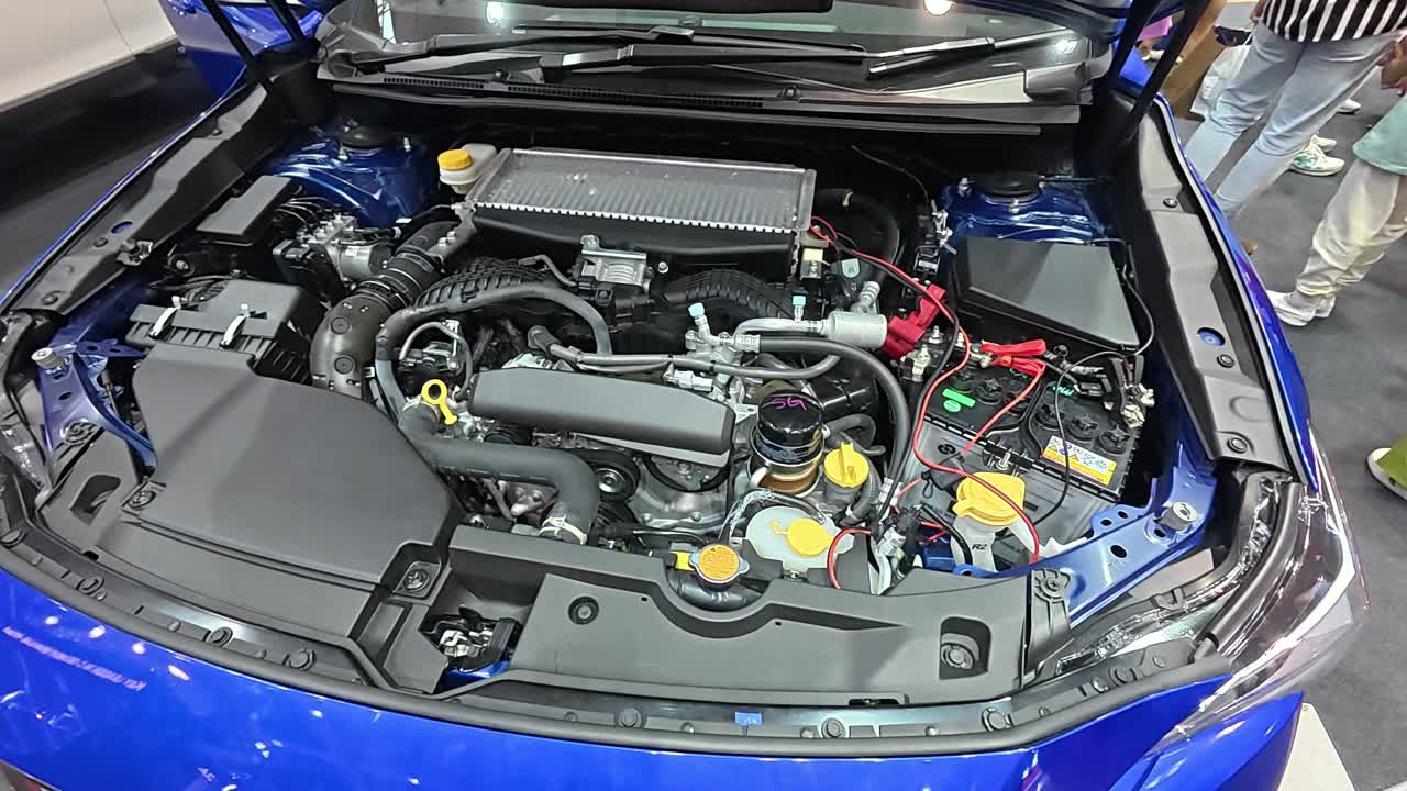 Newly revealed car engine in a showroom. The hood is open, showcasing the powerful engine to potential customers.