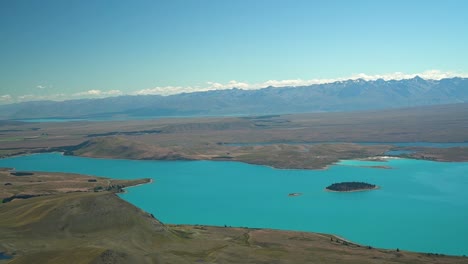 beautiful blue glacier lake tekapo, new zealand from scenic flight plane with montains in background