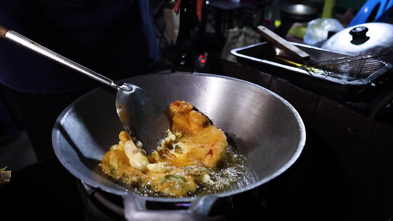Gadesælger tilbereder en omelet i en wok