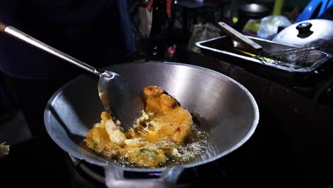 vendedor callejero preparando una tortilla en un wok