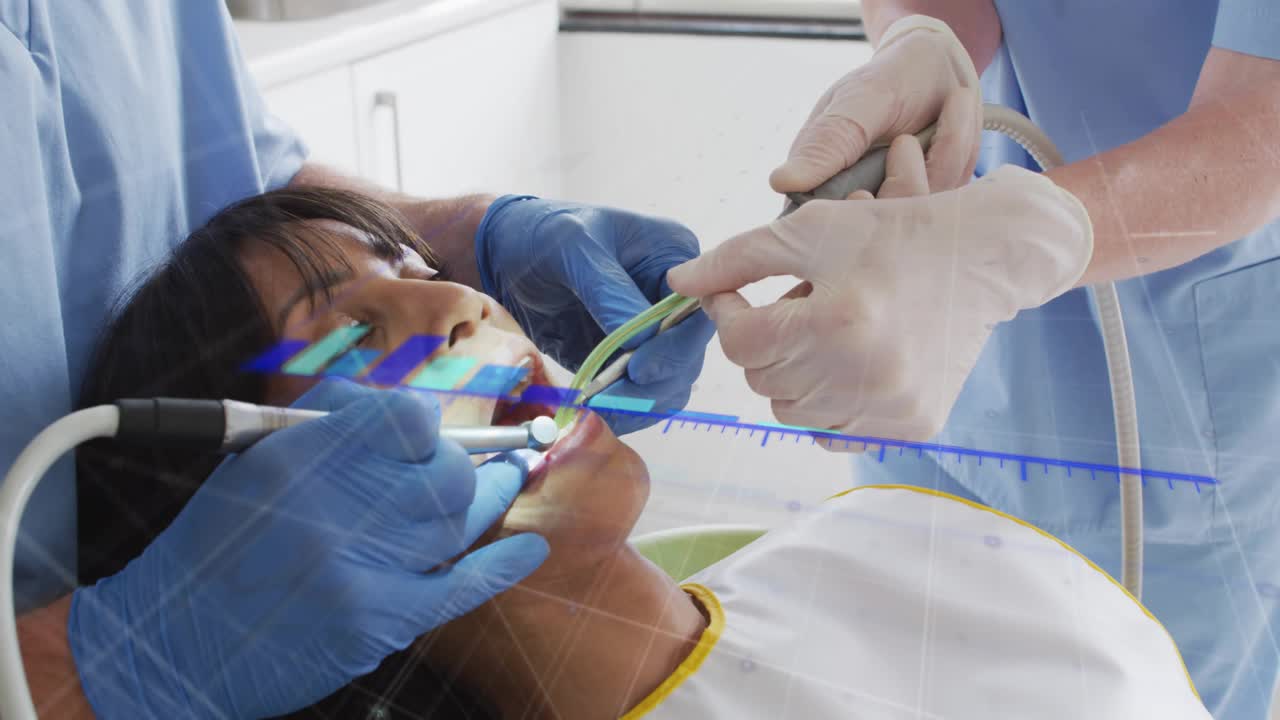 Clinician activating drill, patient reclining, assistant suctioning, blue bars showing dental care