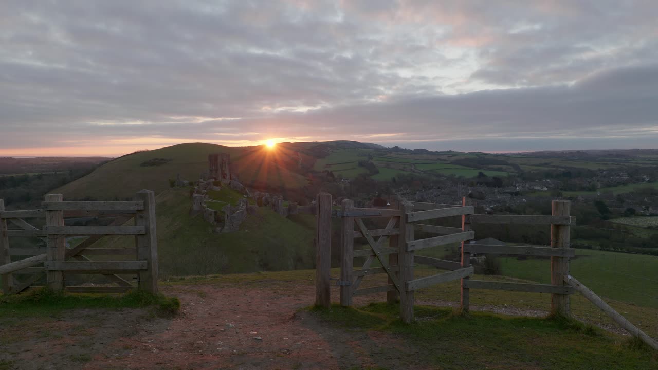 Corfe Castle sunrise with moving clouds over the Purbeck Hills