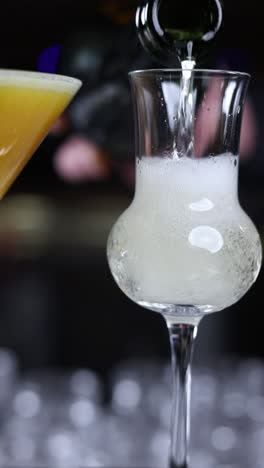 bartender pouring champagne cocktail