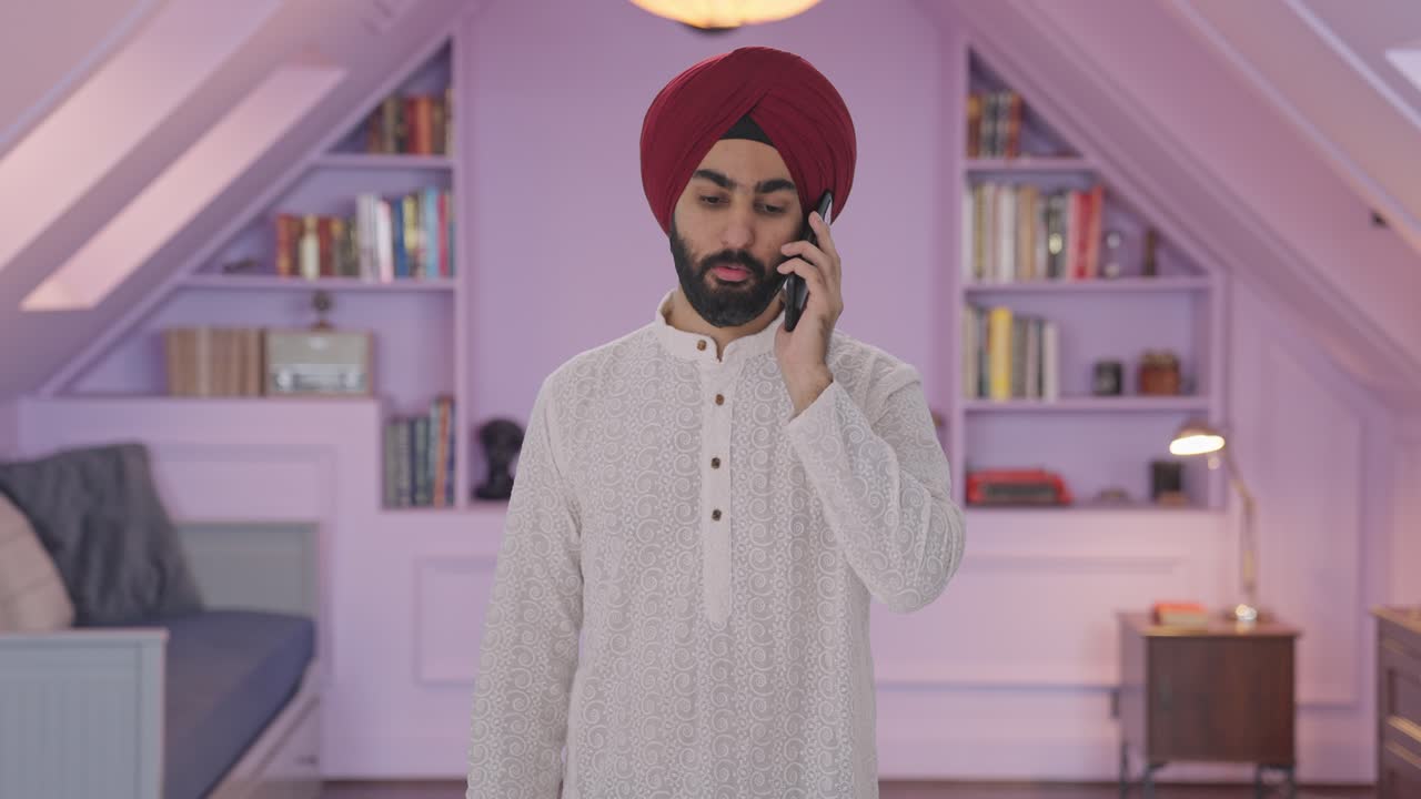 Uomo indiano Sikh che parla al telefono.