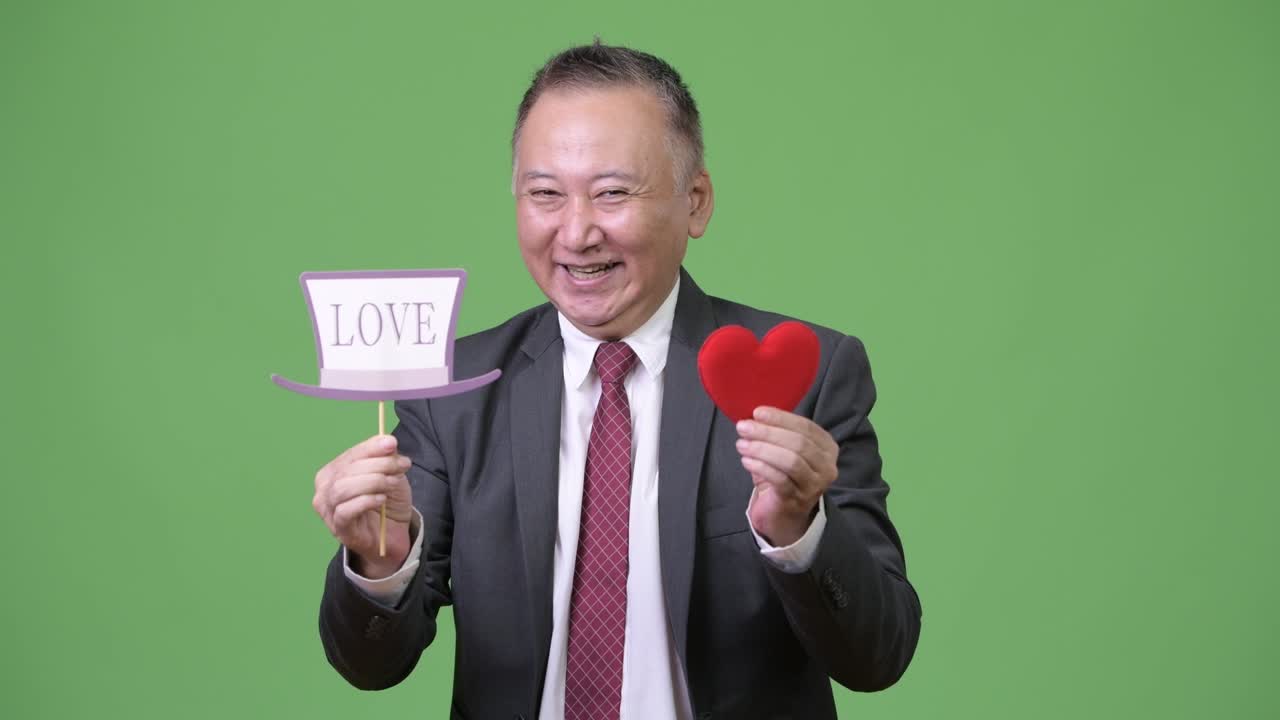 성숙 한 일본인 사업가 가 종이 표지판 을 들고 있다