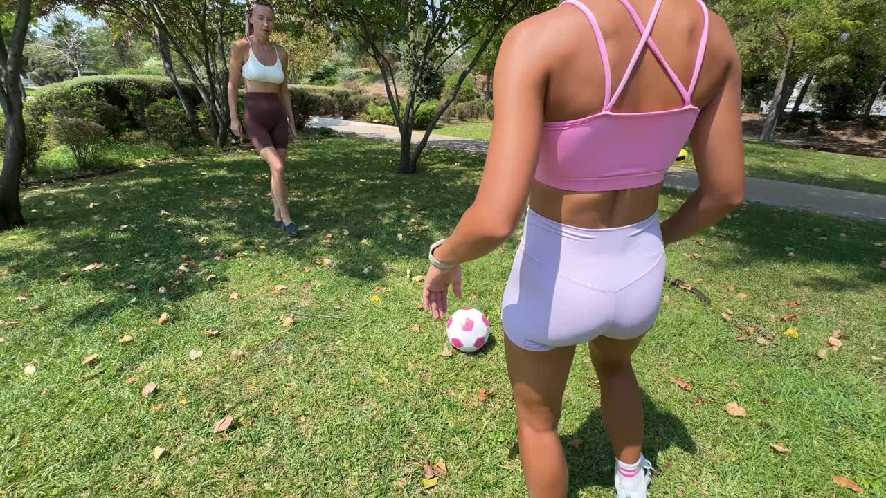 Women playing soccer in the park