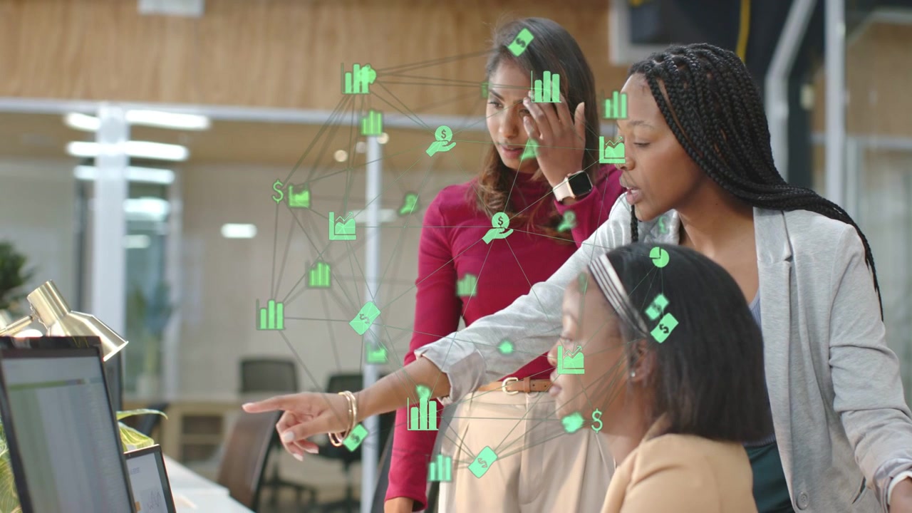 3 women around monitor green overlay popping pointing colleague sitting using mouse reviewing sales