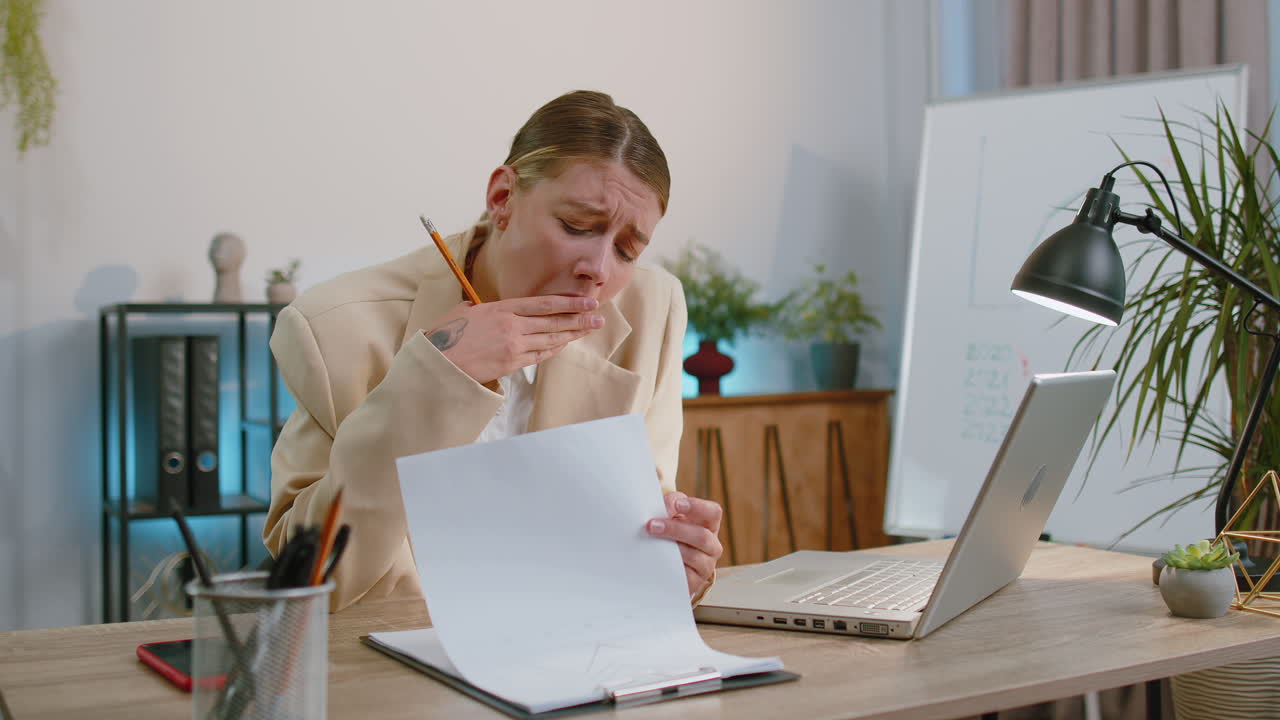 mujer de negocios aburrida y somnolienta trabajadora en una computadora portátil, bostezando, quedándose dormida en la oficina