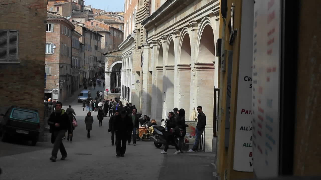 женщина в красной куртке с сумкой выходит из старинного архитектурного здания
