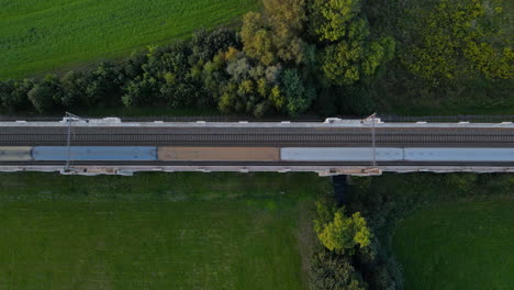 Vista-Superior-De-Las-Vías-Del-Tren-En-Un-Puente-Con-El-Campo-Circundante-Y-Un-Tren-Que-Pasa