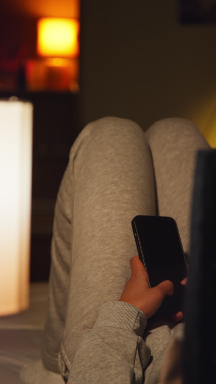 persona que utiliza un teléfono inteligente en la cama por la noche