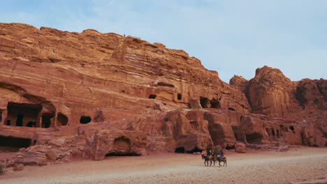 Two-donkeys-in-Petra-Jordan-at-historic-tombs-at-UNESCO-heritage-site-Treasury-Khaznet-carved-into-sandstone-and-limestone