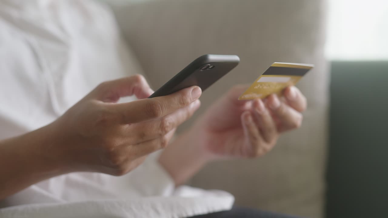 mano de jóvenes mujeres asiáticas están comprando en línea con una tarjeta de crédito en el teléfono inteligente