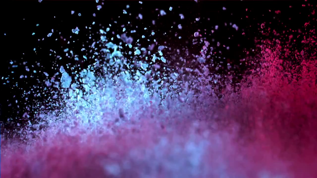 Explosion au ralenti de particules de poudre bleues et roses éclatantes