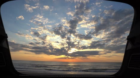 Slider-shot-of-the-sunset-and-sea-view-from-a-car's-trunk