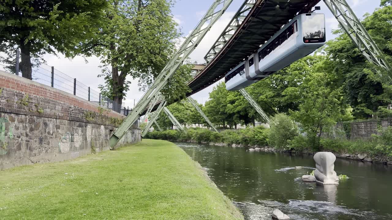 Schwebebahn suspended monorail train passing overhead River Wupper and location Tuffi the elephant fell from the carriage in 1950 - Wuppertal, Germany