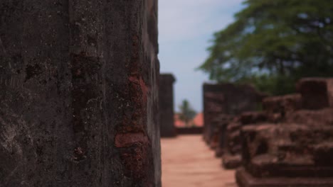 a woman in a yellow dress explores ancient ruins on a sunny day