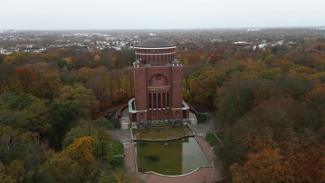 Velká věž stojící uprostřed zeleného parku obklopeného stromy, Hamburk, Německo, Evropa, dron.