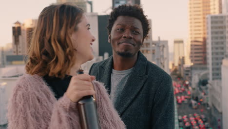 happy multiracial couple laughing having fun enjoying rooftop view of city chatting sharing connection friends drinking alcohol hanging out on weekend