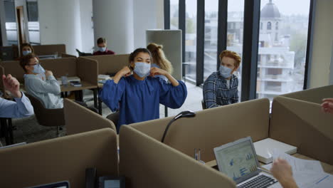 businesspeople taking out medical masks from faces in office