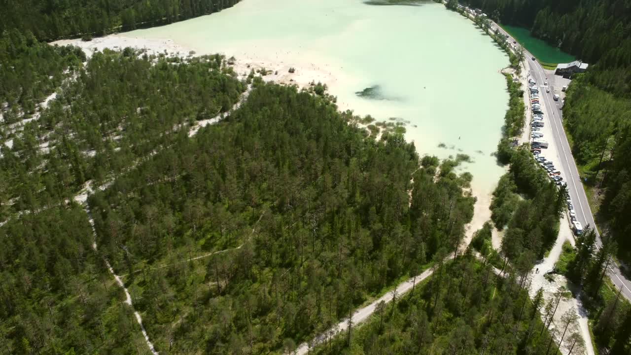 Turisté jezdí na kajaku a plavou v krásném Lago di Landro v Dolomitech