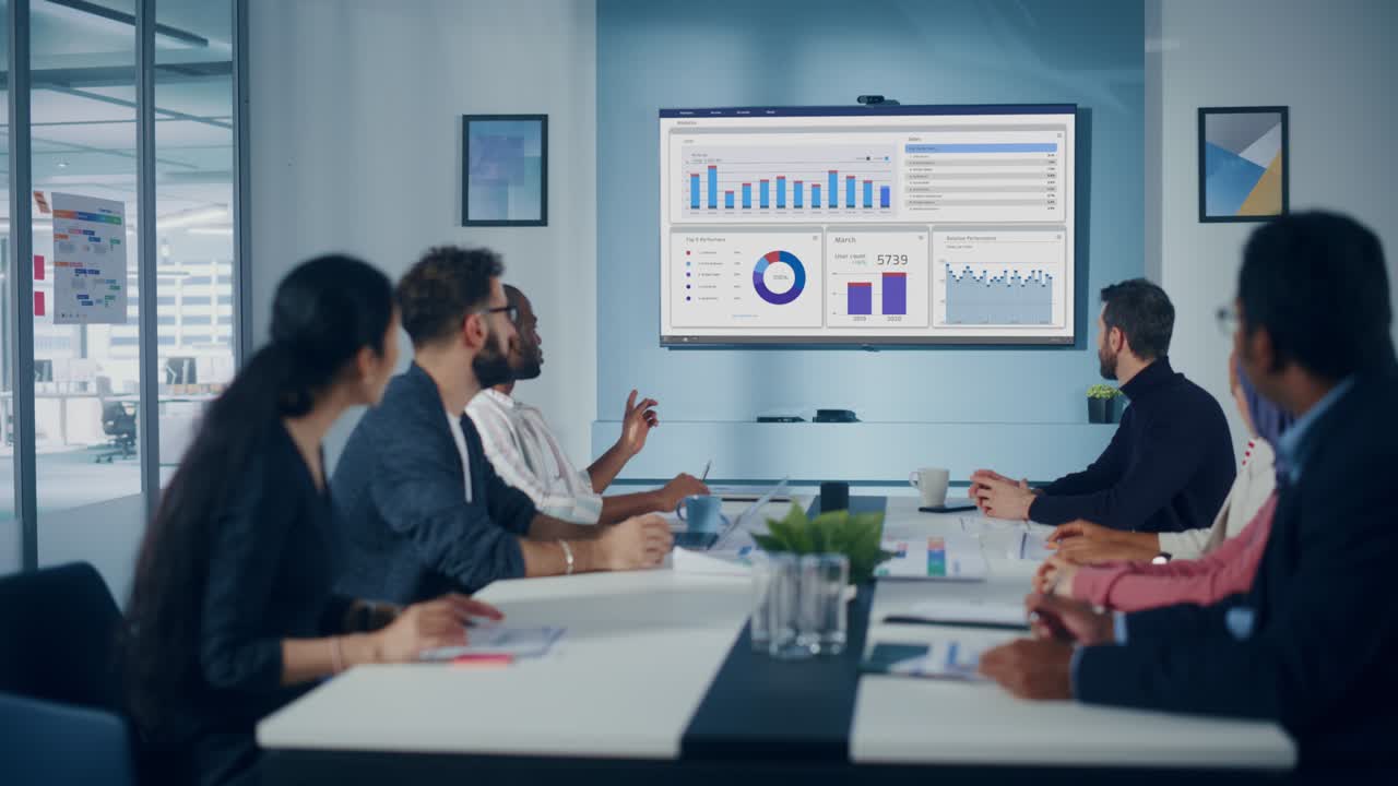 Multi-Ethnic Office Conference Room Meeting: Diverse Team of Successful Managers, Executives Talk, Use Green Screen Chroma Key TV. Businesspeople Investing in Growing e-Commerce Startup. Wide Shot