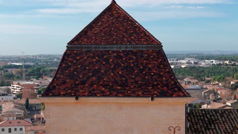 aerial tilt view of the exterior medieval french chateau with scenic cityscape in the background, castries, france